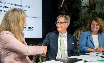 Die Präsidentin von Coopbund, Monica Devilli, freut sich mit Herbert Von Leon, Obmann des Raiffeisenverbandes, über die vertiefte Zusammenarbeit. Im Bild rechts die Landesrätin für das Genossenschaftswesen Rosmarie Pamer.